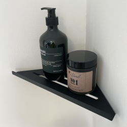 V�gmonteret mat sort hj�rne-shampoohylde af rustfrit st�l med dr�nriller.